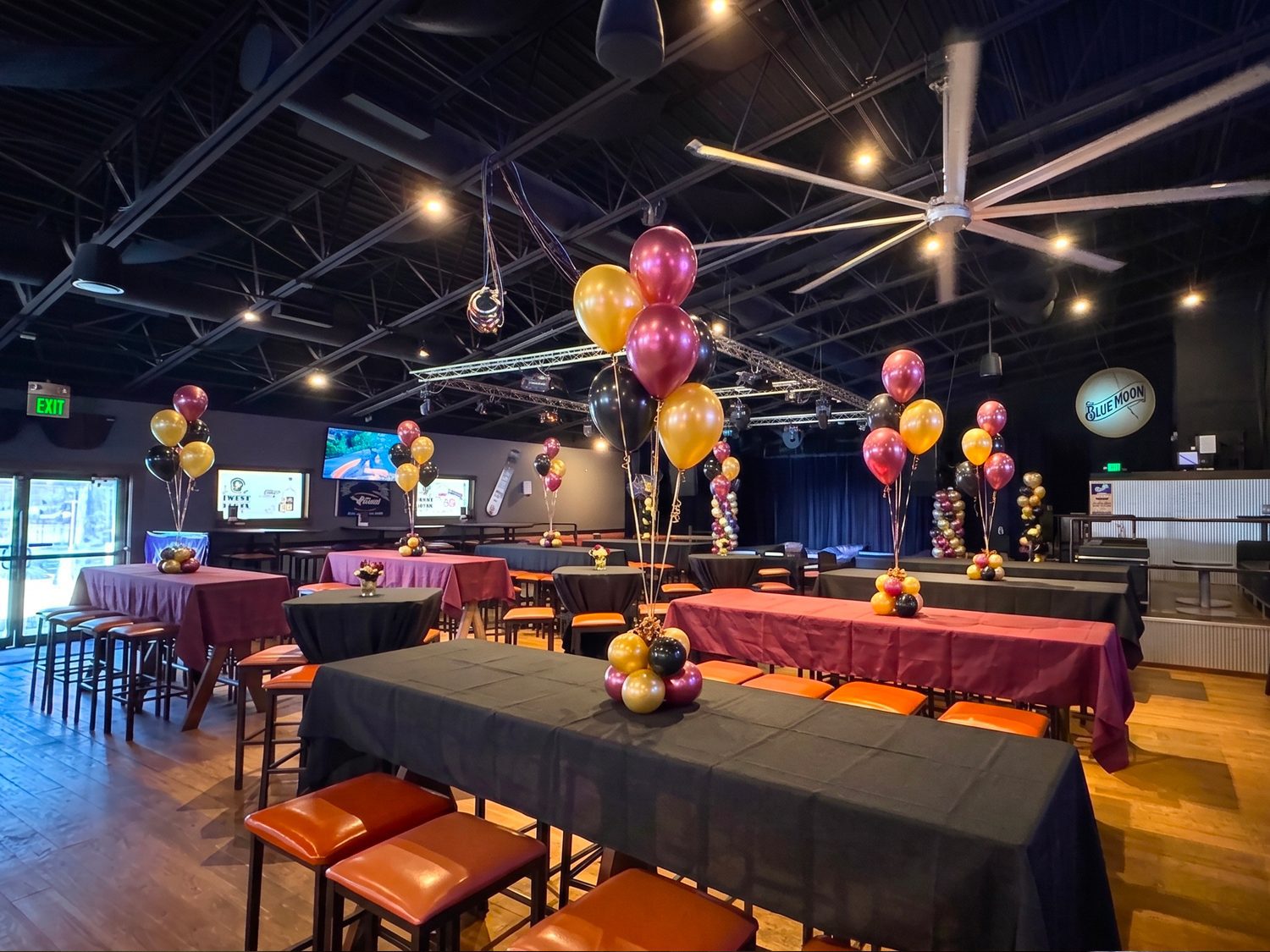 Interior event space at Twain's Tavern with high-top tables, stage, and lighting truss