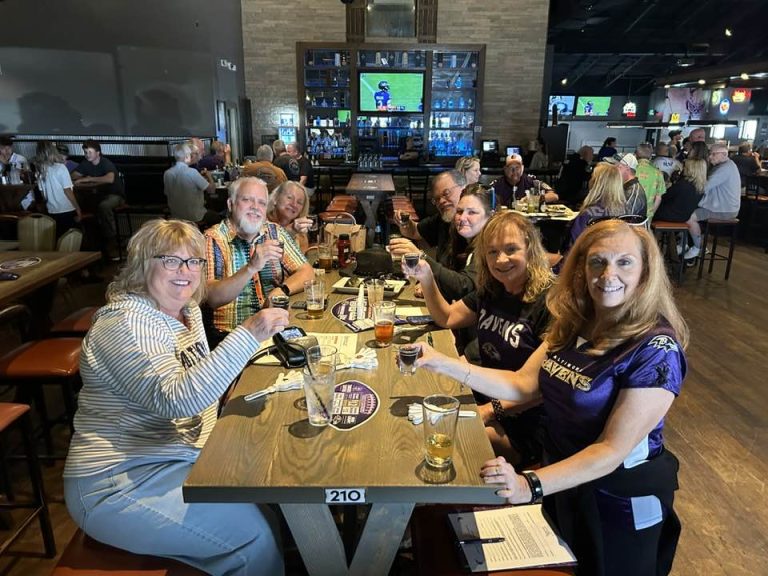 Friends in Ravens gear at a table during a game at Twain's Tavern