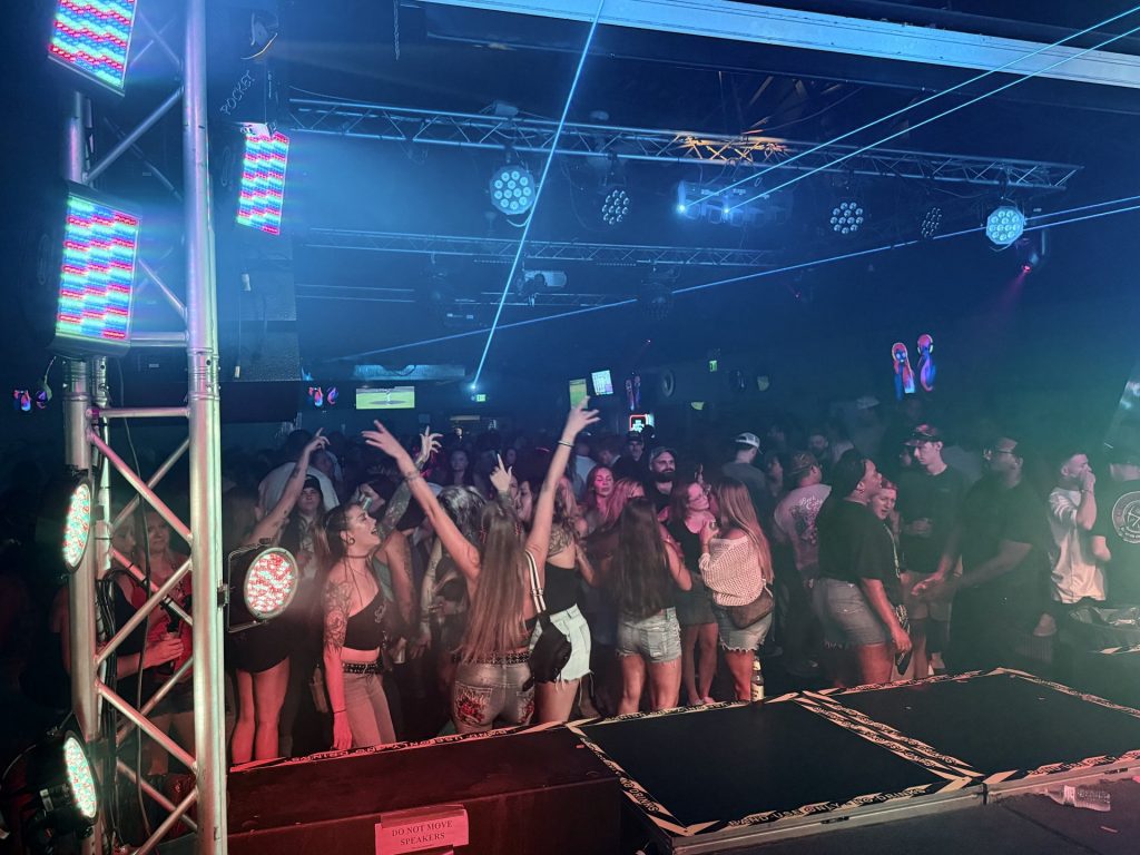 Crowd dancing under the lasers and stage lights at Twain's Tavern