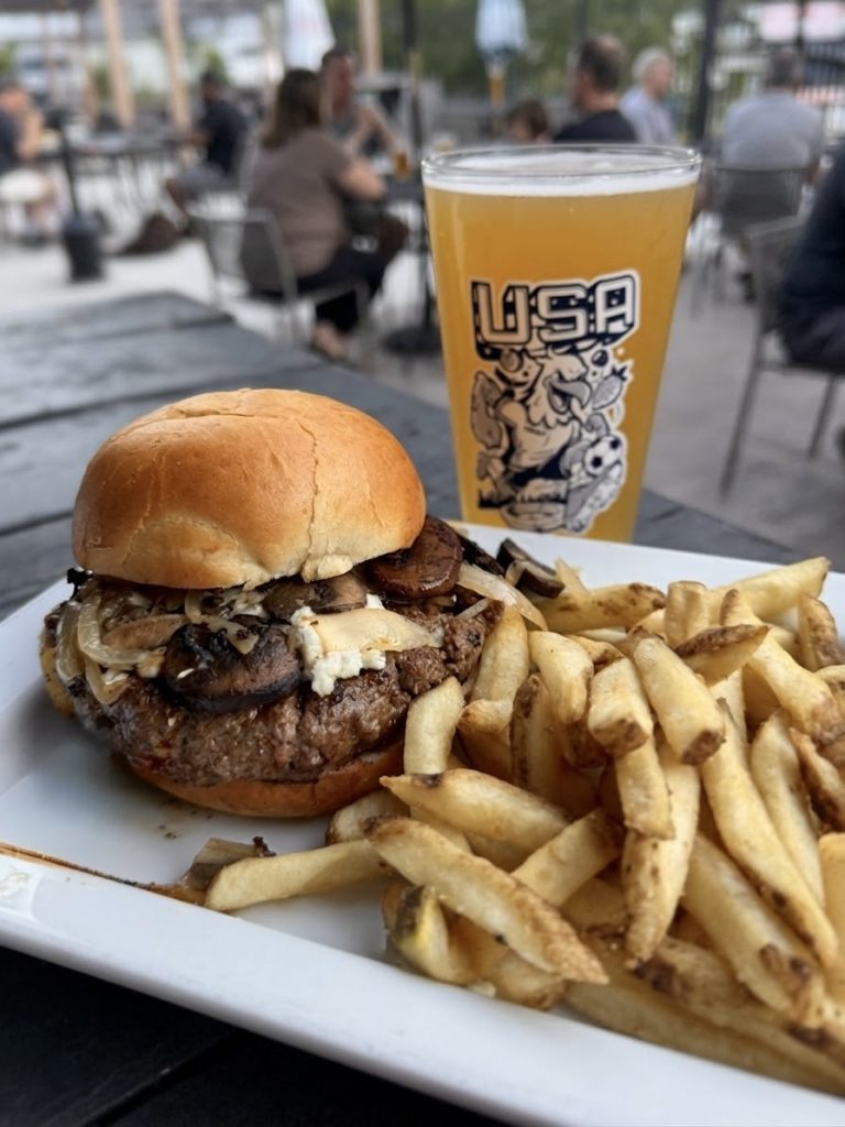 Black & Blue burger with fries and a beer on the patio at Twain's Tavern