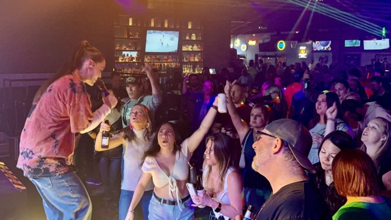 A singer and a crowd singing along at Twain's Tavern