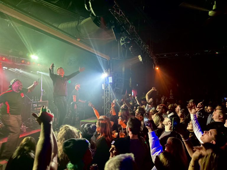 A packed crowd with hands up for a show at Twain's Tavern